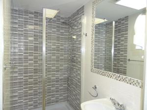 uma casa de banho com um chuveiro, um lavatório e um espelho. em Pensión El Otero 2 em Guadalajara