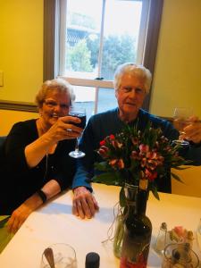 two older people sitting at a table with glasses of wine at The Grenville Hotel and Restaurant in Bay Head