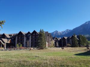 un grand lodge avec des montagnes en arrière-plan dans l'établissement Paradise Resort Club and Spa, à Canmore