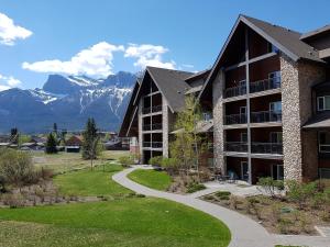 a building with a walkway and mountains in the background at Paradise Resort Club and Spa in Canmore