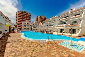 a swimming pool in front of some apartment buildings at Home Maria in Playa de las Americas