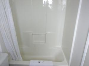uma casa de banho branca com uma banheira e um WC em Trail Motel em Kellogg
