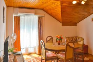 Un comedor con mesa y sillas y una ventana. en Apartment Marina, en Senj