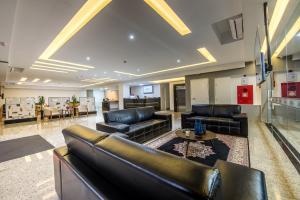 a living room with couches and a table at Prime Hotel Ponta Porã in Ponta Porã