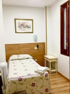 Un pequeño dormitorio con una cama y una mesa. en Hostal Nersan2, en Madrid