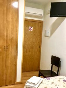 una habitación con una puerta con una señal de no fumadores en Hostal Nersan2, en Madrid