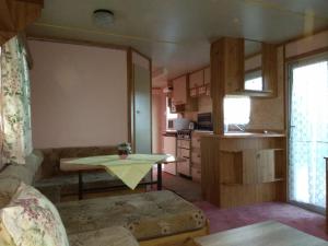 a living room with a couch and a table at Mobilheim Vyhlídka Camp Výrovice in Výrovice +4 photos