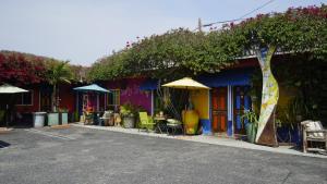 un edificio colorido con mesas, sillas y sombrillas en Villa Brasil Motel en Los Ángeles