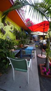 a patio with tables and chairs and a red umbrella at Villa Brasil Motel in Los Angeles