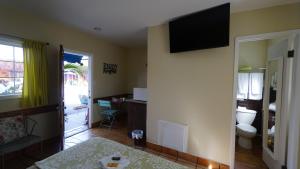 a room with a bed and a television on a wall at Villa Brasil Motel in Los Angeles