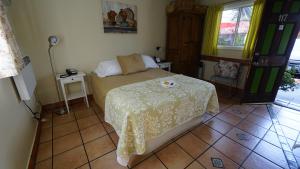 a bedroom with a bed with a yellow blanket on it at Villa Brasil Motel in Los Angeles