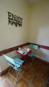 a table with two chairs and a sign on the wall at Villa Brasil Motel in Los Angeles