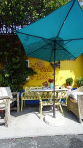 a table with a blue umbrella in front of a building at Villa Brasil Motel in Los Angeles