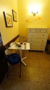 a small table and chair in a room with a dresser at Villa Brasil Motel in Los Angeles