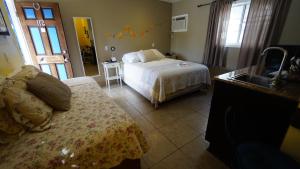 a bedroom with a bed and a sink in it at Villa Brasil Motel in Los Angeles