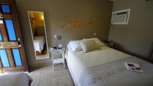 a small bedroom with two beds and a mirror at Villa Brasil Motel in Los Angeles