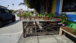 a sign on a table with flowers on a sidewalk at Villa Brasil Motel in Los Angeles