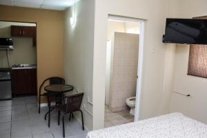 a room with a bathroom with a table and a toilet at Coconut Inn in Palm-Eagle Beach