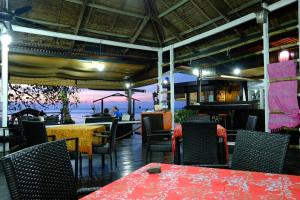 a restaurant with tables and chairs and a view of the ocean at Melina Beach Resort in Tioman Island +49 photos