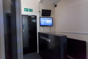 a room with a wall with a computer and a sign on the wall at Fenham Hotel express in Newcastle upon Tyne