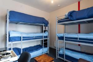 a room with three bunk beds with blue sheets at Fenham Hotel express in Newcastle upon Tyne