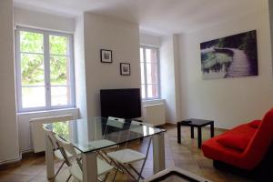 - un salon avec une table en verre et un canapé rouge dans l'établissement Appartements Coeur de Village, à Saint-Jean-du-Bruel