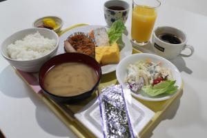 a tray of food with bowls of food and drinks at Business Hotel Raicho in Koshigaya