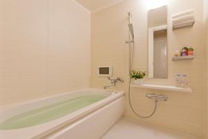 a bathroom with a tub and a sink and a mirror at Hotel BIX チェックイン23時 変更不可 in Tokyo