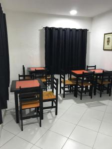 um grupo de mesas e cadeiras num quarto com cortinas pretas em Hotel Romance (Adults Only) em São Paulo