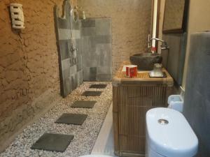 La salle de bains est pourvue d'une douche, de toilettes et d'un lavabo. dans l'établissement Kerta Family Bed and Breakfast, à Ubud