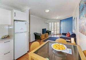 a kitchen and living room with a bowl of oranges on a table at Beachfront @ Scarbs in Perth