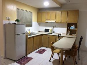 a small kitchen with a table and a refrigerator at 2 bed Kempas D2-705 Genting Highland in Genting Highlands