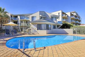 a swimming pool in front of a house at Beachfront @ Scarbs in Perth