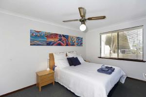 a bedroom with a bed and a ceiling fan at Beachfront @ Scarbs in Perth