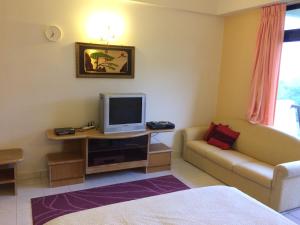 a living room with a couch and a television at 2 bed Kempas D2-705 Genting Highland in Genting Highlands