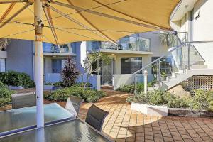 een patio met een parasol en een zwembad bij Beachfront @ Scarbs in Perth