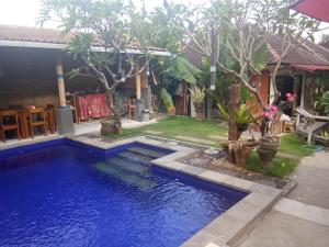 a swimming pool in the yard of a house at Kerta Family Bed and Breakfast in Ubud