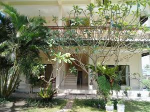 Un bâtiment avec une bande de plantes devant lui dans l'établissement Purnama di Bisma, à Ubud