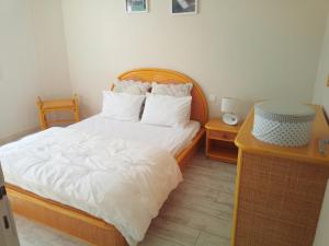 1 dormitorio con 1 cama con sábanas y almohadas blancas en Maison du Port, en Narbonne-Plage