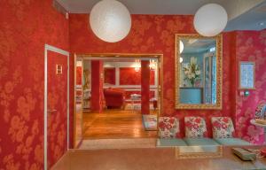 a living room filled with furniture and a red wall at Hotel Louvre Bons Enfants in Paris
