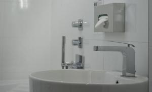 La salle de bains est pourvue d'un lavabo et d'un robinet. dans l'établissement Hotel Louvre Bons Enfants, à Paris
