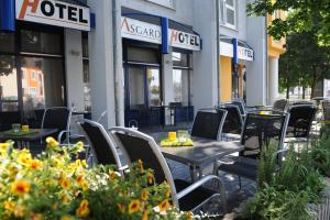 a row of tables and chairs in front of a hotel at Asgard Hotel in Worms