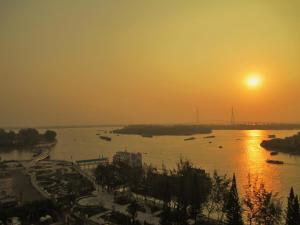 een zonsondergang over een rivier met boten erin bij Kim Tho Hotel in Can Tho