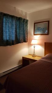 Oak PointにあるHWY6HOTELのベッドルーム1室(ベッド1台、デスクのランプ付)