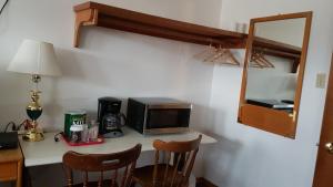 a kitchen with a microwave and a table with chairs at HWY6HOTEL in Oak Point