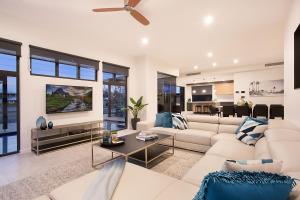 ein Wohnzimmer mit einem weißen Sofa und einem Tisch in der Unterkunft Jewel of Broadbeach in Gold Coast