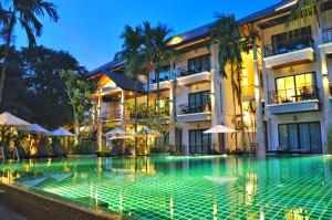 a hotel with a swimming pool in front of a building at Navatara Phuket Resort - SHA Extra Plus in Rawai Beach