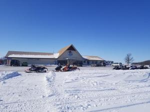 a group of snowmobiles in the snow in front of a building at HWY6HOTEL in Oak Point