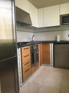 una cucina con armadi in legno e frigorifero in acciaio inossidabile di Seaside Idyll a Viareggio