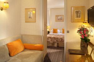 パリにあるオ マノワール サン ジェルマンのソファとベッド付きのホテルルーム